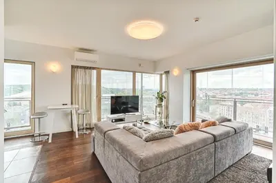 a living room with a large couch and a television at Vilnius city best view apartments in Vilnius
