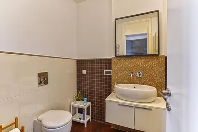 a bathroom with a sink and a toilet and a mirror at Vilnius city best view apartments in Vilnius