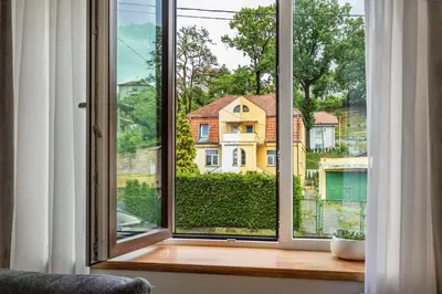 an open window with a view of a house at Bright and Cosy 1BDR apartment Kaunas Centre in Kaunas