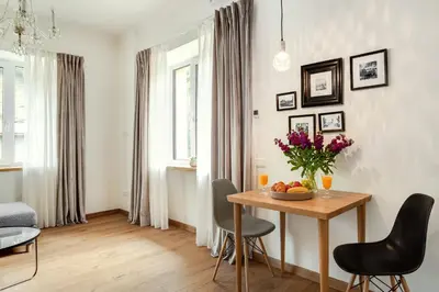 a living room with a table with a vase of flowers at Bright and Cosy 1BDR apartment Kaunas Centre in Kaunas
