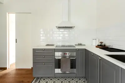 a kitchen with gray cabinets and a stove at Bright and Cosy 1BDR apartment Kaunas Centre in Kaunas