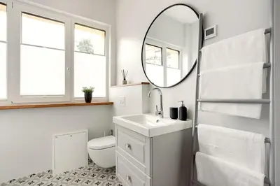 a white bathroom with a sink and a mirror at Bright and Cosy 1BDR apartment Kaunas Centre in Kaunas