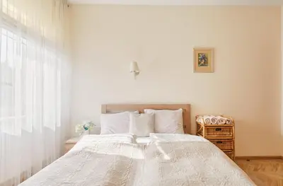a bedroom with a large bed with white sheets at Old Town apartment in Kaunas