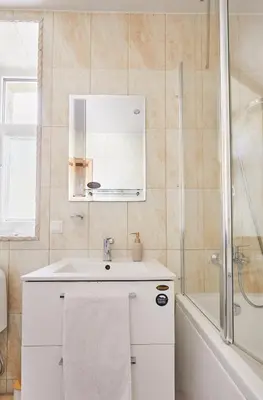 a white bathroom with a sink and a shower at Old Town apartment in Kaunas