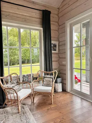 a room with two chairs and a table and windows at Aviečių vila in Sumiliszki