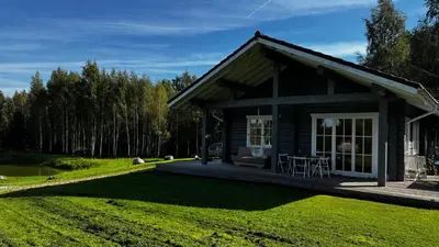 a small log cabin with a table in the grass at Aviečių vila in Sumiliszki