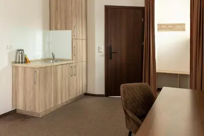 a kitchen with a sink and a table and a door at Svečių Namai TEN in Marijampolė