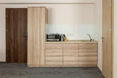 a kitchen with a microwave on a counter and a door at Svečių Namai TEN in Marijampolė