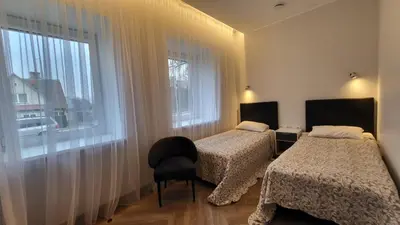 a bedroom with two beds and a window at Svečių namai 