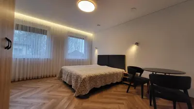 a bedroom with a bed and a table and chairs at Svečių namai 