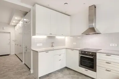 a white kitchen with white cabinets and a stove at Twin apartments 3 Bedr by Reside Baltic in Vilnius