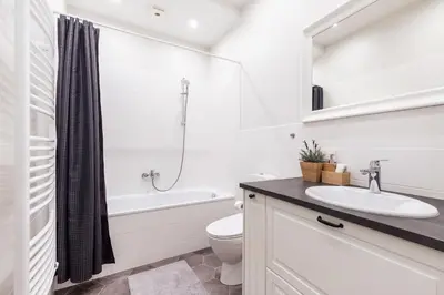a white bathroom with a sink and a toilet at Twin apartments 3 Bedr by Reside Baltic in Vilnius