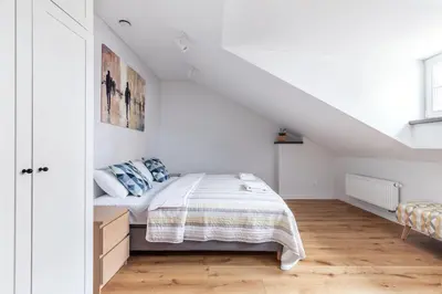 a white bedroom with a bed in a attic at Twin apartments 3 Bedr by Reside Baltic in Vilnius