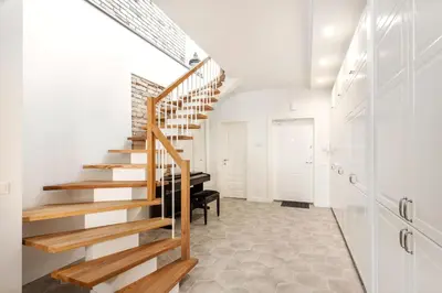 a staircase in a white room with a piano at Twin apartments 3 Bedr by Reside Baltic in Vilnius