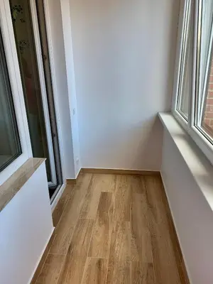 an empty room with wooden floors and windows at Alytus Apartament in Alytus