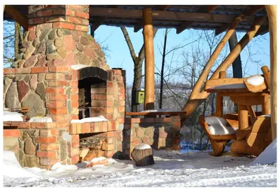 a brick oven with a chair in the snow at Sodyba Širvynė in Užpaliai