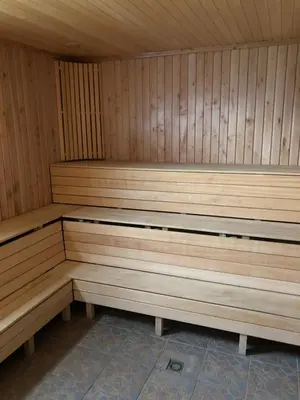 a wooden sauna with wooden benches in a room at Paukoje Apartamentai in Ignalina