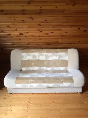 a bed in a room with a wooden ceiling at Paukoje Apartamentai in Ignalina