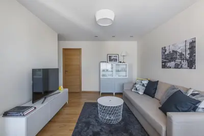 a living room with a couch and a tv at Sun City Apartment in Šiauliai