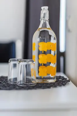 a bottle and a glass container on a table at Sun City Apartment in Šiauliai