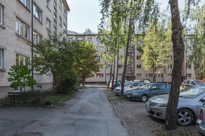 a parking lot with cars parked in front of buildings at Sun City Apartment in Šiauliai