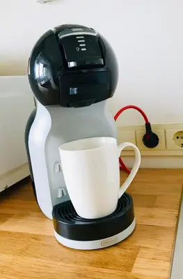 a coffee maker with a cup on top of it at Cozy apartment with lake view in Trakai