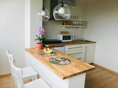 a kitchen with a table with a plate of fruit on it at Cozy apartment with lake view in Trakai