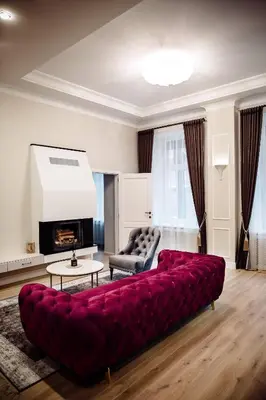a large red couch in a living room with a fireplace at Kranto apartaments in Panevėžys