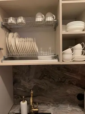a kitchen cabinet filled with plates and bowls and dishes at Kranto apartaments in Panevėžys