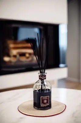a glass bottle with sticks in it on a table at Kranto apartaments in Panevėžys