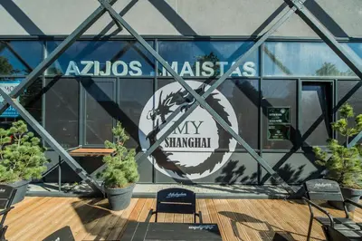 a glass building with a sign that reads akolis malias myswitzerland at Zaliakalnio terasos apartamentai in Kaunas