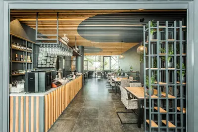 a restaurant with tables and chairs and a bar at Zaliakalnio terasos apartamentai in Kaunas