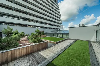 a garden in the courtyard of a building at Zaliakalnio terasos apartamentai in Kaunas