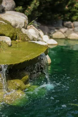 a waterfall in a pool of water with rocks at Armenia in Garliava