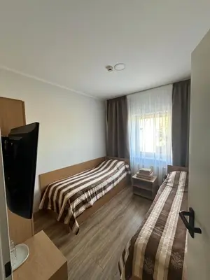 a small room with two beds and a television at Armenia in Garliava