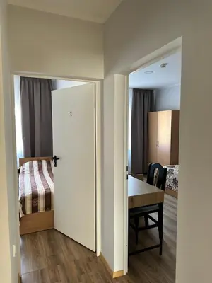 a room with a desk and a bedroom with a bed at Armenia in Garliava