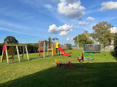 a playground with play equipment on a grass field at Armenia in Garliava