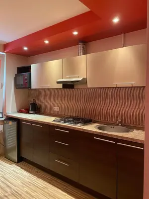 a kitchen with brown cabinets and a sink at Trumpalaikė buto nuoma,apgyvendinimas - bekontaktis įėjimas in Rokiškis