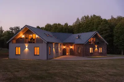 a house with a gambrel roof with a garage at Lake & Library boutique Hotel in Ignalina