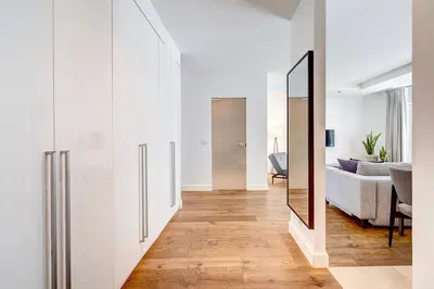 a hallway with a mirror and a living room at Vilnius Apartments & Suites in Vilnius