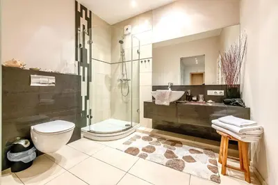 a bathroom with a shower and a toilet and a sink at Vilnius Apartments & Suites in Vilnius