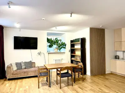 a living room with a table and a couch at Mini Home Bookshop Studios in Vilnius
