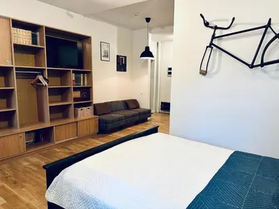 a living room with a bed and a couch at Mini Home Bookshop Studios in Vilnius