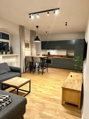 a living room and kitchen with a couch and a table at Mini Home Bookshop Studios in Vilnius