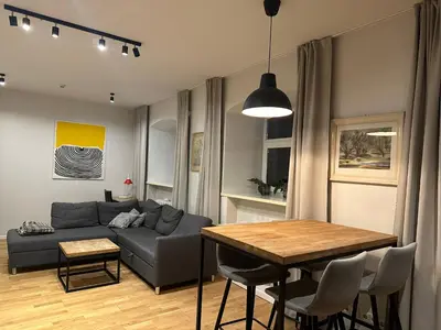 a living room with a couch and a table at Mini Home Bookshop Studios in Vilnius