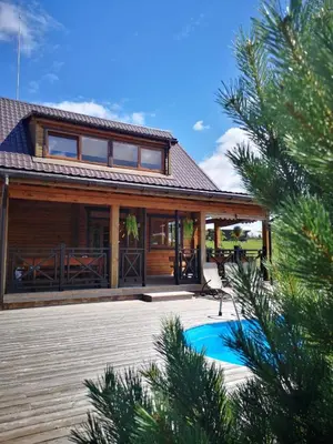 a house with a pool in front of it at Abromiškių Sodyba in Elektrėnai