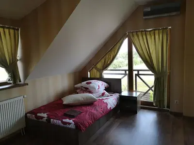 a bedroom with a bed in a room with windows at Abromiškių Sodyba in Elektrėnai