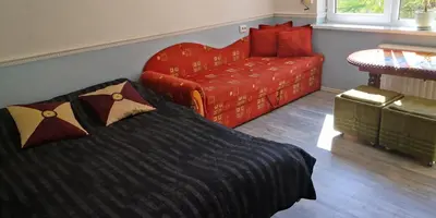 a bedroom with a bed and a couch at KAMBARIŲ nuoma Kaune - in Kaunas