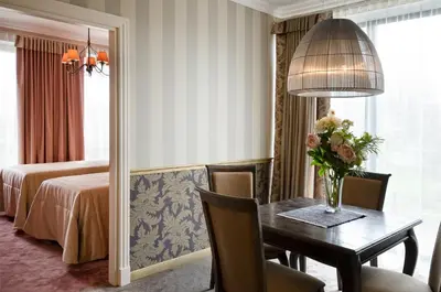 a hotel room with a table and a bedroom at Ursula Royal Apartments in Druskininkai
