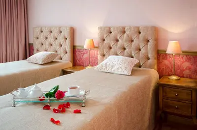 a hotel room with two beds with roses on the bed at Ursula Royal Apartments in Druskininkai
